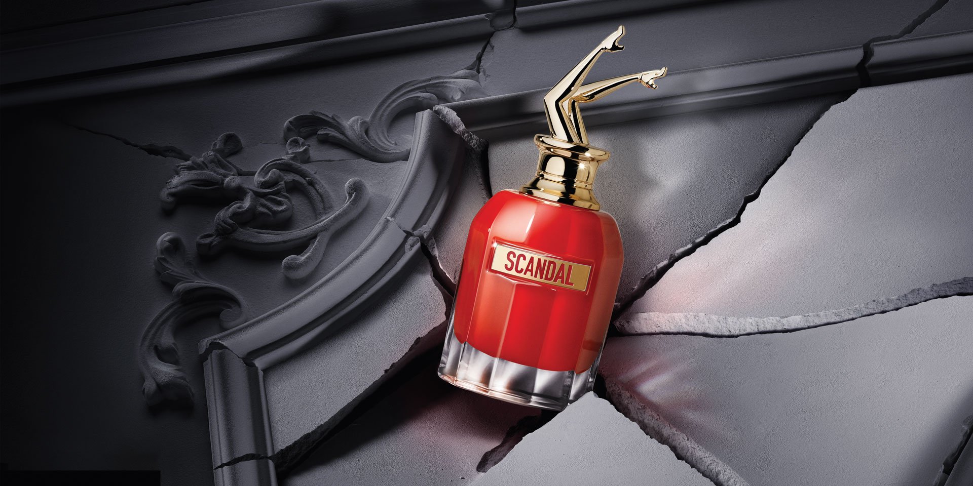 Scandal le Parfum bottle with red phone on grey background