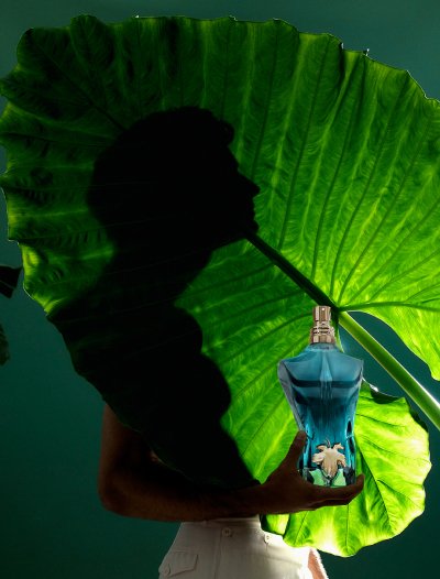 Male model behind a leaf with Le Beau EDT bottle on green background