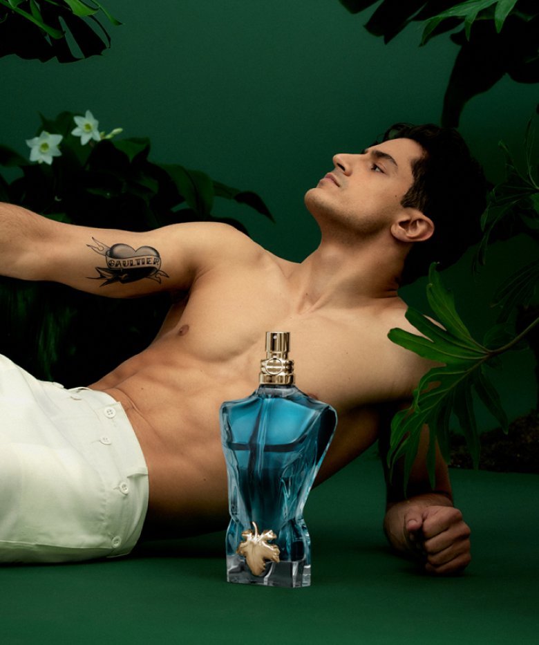 Male model and Le Beau EDT bottle on dark green background
