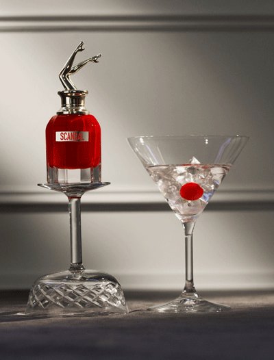 still life flacon Scandal rouge sur verres cocktail et fond gris