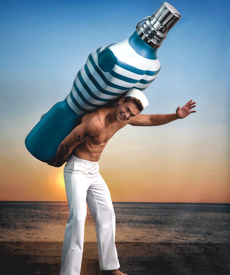Le Male giant bottle on male model, with sunset as a background