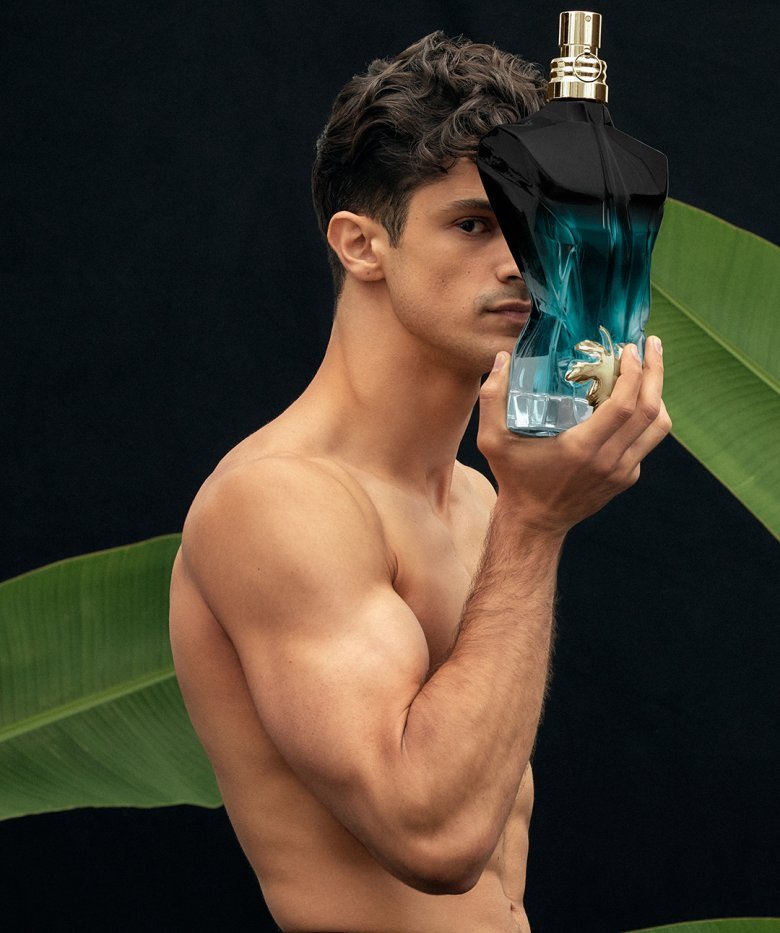 le beau le parfum holds the bottle in his hand